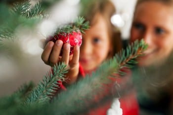 Familie schmückt Weihnachtsbaum